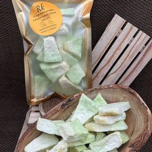 May include: A bag of freeze-dried green honeydew melon. The bag is labeled "Rk Freeze dried goodies Green Honeydew Melon Keep it zipped Keep it crisp". The melon is in a wooden bowl.