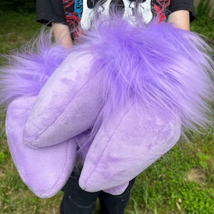 May include: Two plush purple hand puppets with fluffy fur. The puppets are shaped like a hand with long fingers.