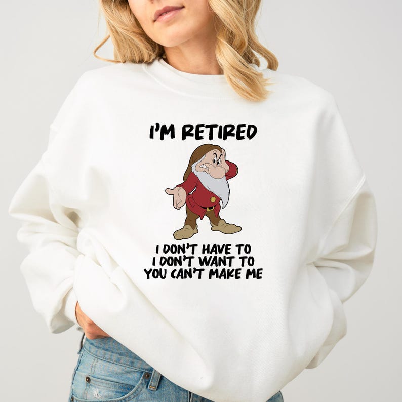 May include: White sweatshirt with the text "I'M RETIRED" above a cartoon image of a dwarf character. Below the image, the text reads "I DON'T HAVE TO I DON'T WANT TO YOU CAN'T MAKE ME".