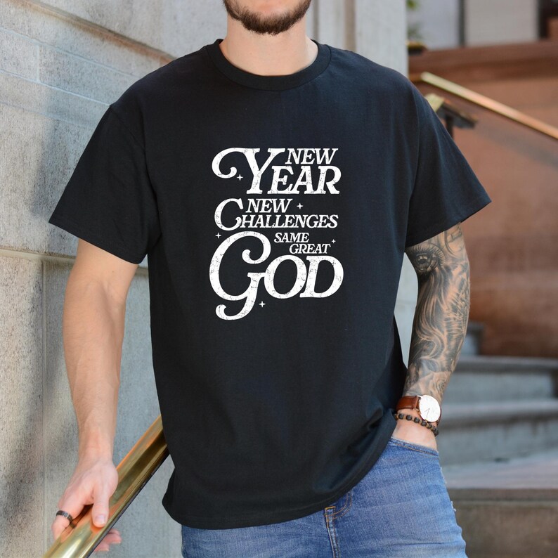 May include: Black t-shirt with a white graphic that reads "New Year New Challenges Same Great God".