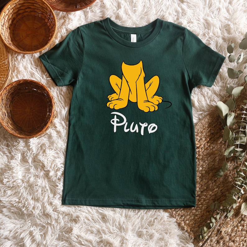May include: A dark green t-shirt with a cartoon image of Pluto the dog in a sitting position. The text "Pluto" is printed in white below the image.