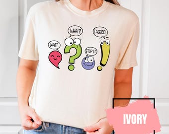 May include: A white t-shirt with a graphic of cartoon punctuation marks with faces. The punctuation marks are a question mark, an exclamation point, a comma, and a period. The text on the shirt says "Wait", "What?", "Stop It", and "I Agree!"