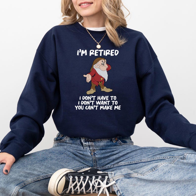 May include: Navy blue sweatshirt with the text "I'M RETIRED" and a cartoon image of a dwarf. Below the image, the text reads "I DON'T HAVE TO I DON'T WANT TO YOU CAN'T MAKE ME".