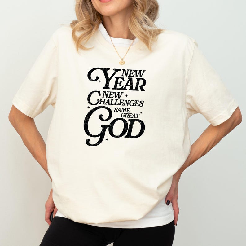 May include: A white t-shirt with a black graphic that reads "New Year New Challenges Same Great God".