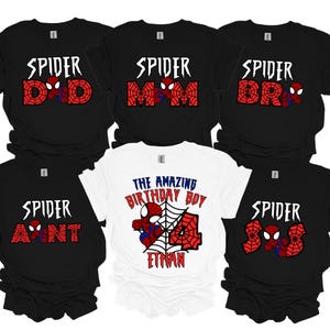 May include: A selection of black and white t-shirts with Spider-Man graphics. The shirts have the word "SPIDER" above family titles such as "DAD," "MOM," "BRO," and "AUNT," plus a birthday shirt for "ETHAN."