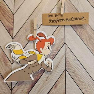 May include: A cartoon illustration of a person with red hair wearing a brown coat and a yellow and white scarf, running to the right. The art is by Stephen McCranie.