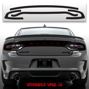 May include: A gray Dodge Charger SRT with black taillight tint overlays. The image shows the rear of the car with the word "CHARGER" and "SRT" visible. The text "VENGEANCE VINYL .CO" is at the bottom.