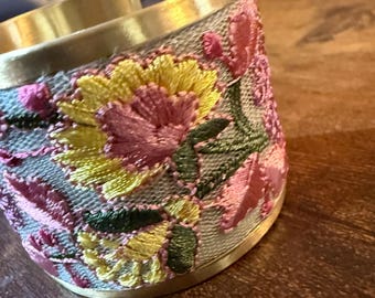 Broderat guldfärgat armband med blommig flexdesign och vårblommor