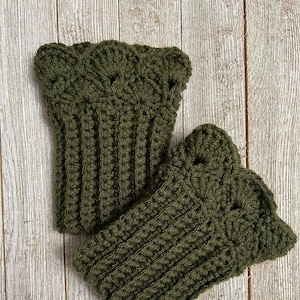 May include: A pair of green crocheted boot cuffs with a decorative top edge. The cuffs are made with a textured stitch and are folded over.
