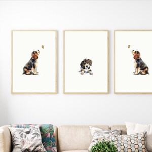May include: Three framed watercolour paintings of a beagle puppy. Each painting features the puppy in a different pose, looking up at a butterfly.