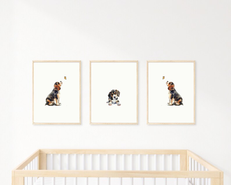May include: Three watercolour paintings of a beagle puppy looking up at a butterfly. The puppy is brown, black, and white. The butterfly is yellow. The paintings are framed in natural wood.