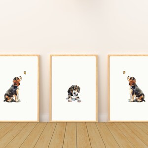 May include: Three watercolour paintings of a beagle puppy in different poses. The puppy is looking up at a butterfly in each image. The paintings are framed in natural wood frames.