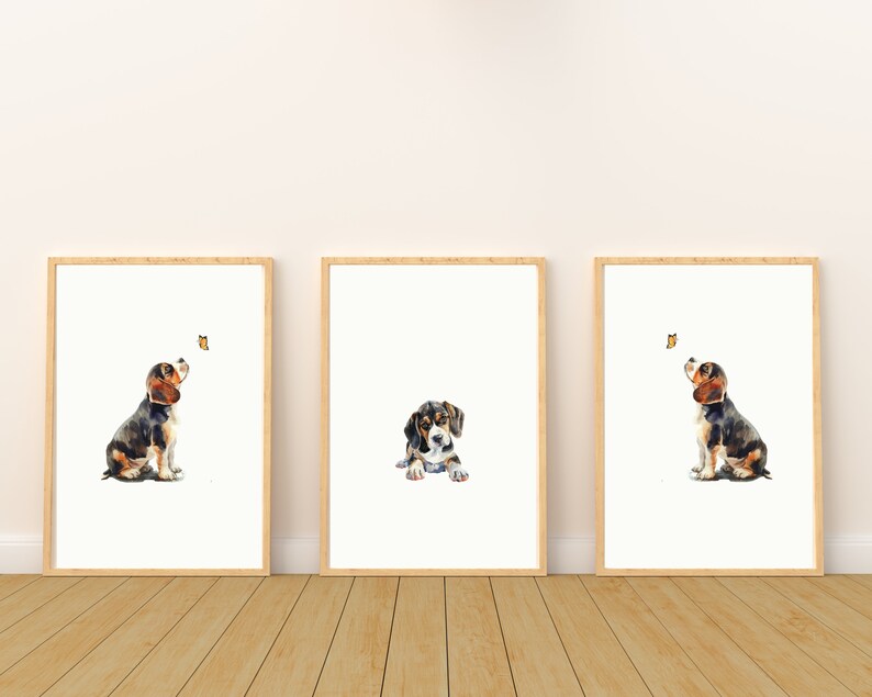 May include: Three watercolour paintings of a beagle puppy in different poses. The puppy is looking up at a butterfly in each image. The paintings are framed in natural wood frames.