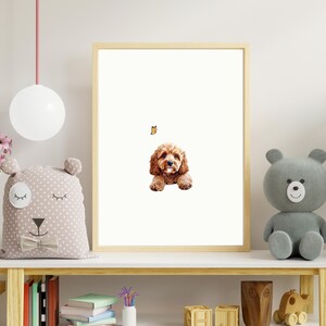 May include: A framed print of a brown and white dog with a butterfly above it. The print is hanging on a white wall above a wooden shelf with a stuffed animal and books.