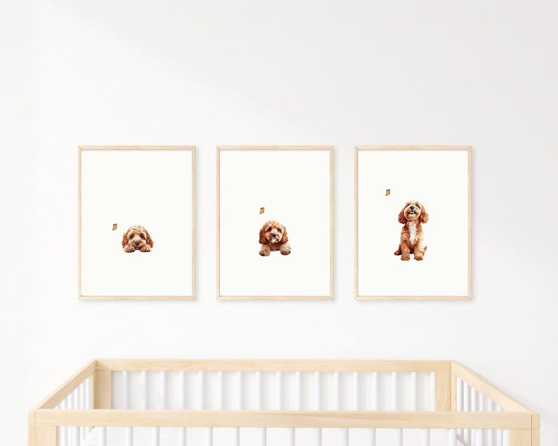 May include: Three framed prints of a brown and white dog in different poses. The dog is looking at a butterfly in each print. The prints are on a white wall above a wooden crib.