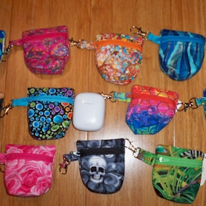 Op de afbeelding: Twaalf kleine ritsjes met verschillende kleurrijke patronen en ontwerpen. De tasjes hebben een sleutelhanger en zijn perfect om kleine spullen zoals sleutels, oordopjes of munten in te bewaren.