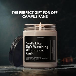 May include: A scented soy wax candle in a clear glass jar with a black lid. The label reads: THE PERFECT GIFT FOR OFF CAMPUS FANS, sweetwickco, Smells Like She&rsquo;s Watching Off Campus Again, A Scented Soy Wax Candle Infused With The Aroma Of Romantic Tension In Every Flame, Soy Wax Blend, 50-60 Hours.
