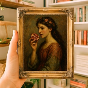May include: A framed painting featuring a woman holding a pomegranate. The artwork has a gold ornate frame. The woman is wearing a red and green dress and a floral crown. The painting is set against a backdrop of a bookshelf.