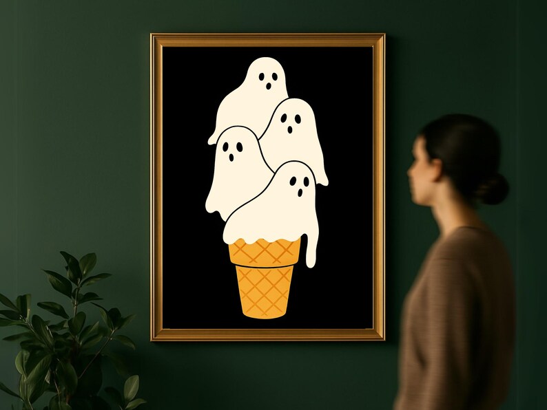 May include: A framed art print featuring a whimsical design. The artwork depicts four white ghost figures stacked on top of a waffle cone against a black background. The cone is a light orange color.