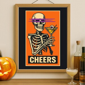 May include: A framed Halloween-themed print featuring a skeleton holding a cocktail with an eyeball olive. The skeleton has purple lines over its eyes. The word "CHEERS" is at the bottom. A carved pumpkin sits in front.