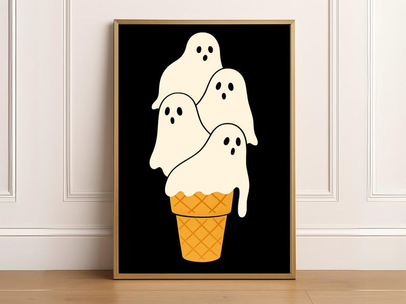 May include: A framed art print featuring a whimsical design of four ghost figures stacked like ice cream on top of a waffle cone. The ghosts are white with black eyes and mouths, set against a black background. The cone is orange.