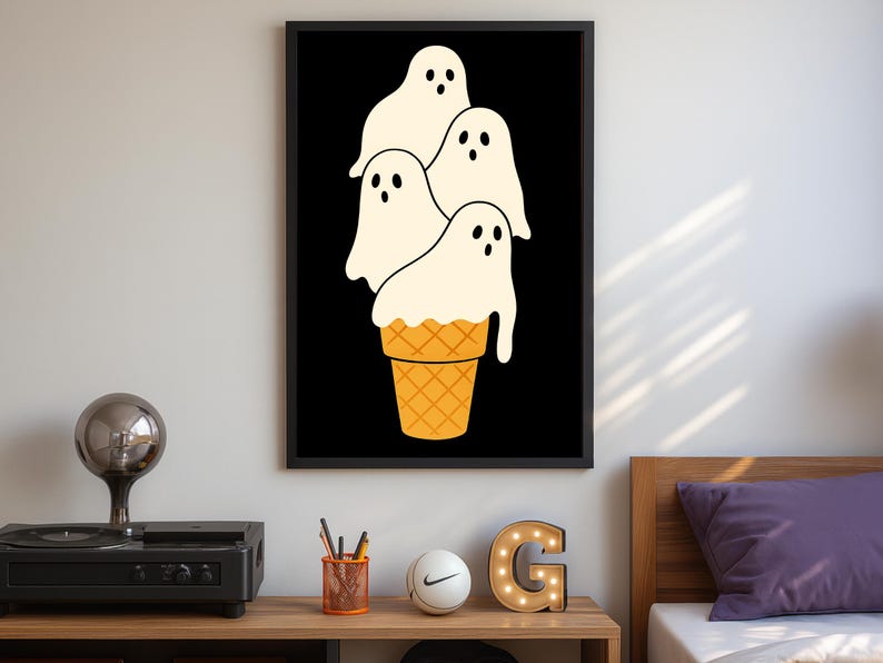 May include: A framed art print featuring a whimsical illustration of four ghost figures resembling ice cream scoops atop a waffle cone. The ghosts are white with black eyes and the cone is orange. The background is black.