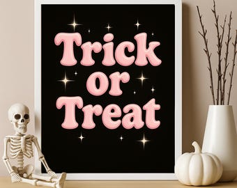 May include: A framed black poster with the words "Trick or Treat" in pink bubble letters, surrounded by starbursts. A small skeleton figurine and a white pumpkin sit on a wooden shelf in front of the poster.