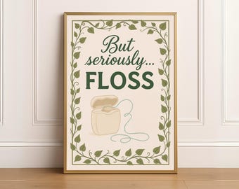 May include: A framed print with a gold border and a cream background. The print features the words "But seriously... FLOSS" in dark green, with a drawing of a floss container and floss. A green leaf border surrounds the text.