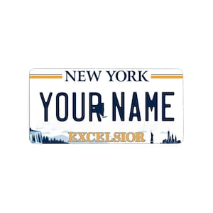Könnte beinhalten: Ein weißes New York-Kennzeichen mit dem Text "NEW YORK" oben und "YOUR NAME" in blauen Buchstaben. Das Wort "EXCELSIOR" ist goldfarben, mit einer Wasserfall- und Skyline-Grafik.