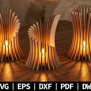 Peut inclure: Trois bougeoirs en bois clair composés de lattes verticales disposées en structures courbes ajourées. Chaque bougeoir contient une bougie allumée diffusant une lueur chaude. Le texte SVG | EPS | DXF | PDF | DWG figure en bas de l'image.