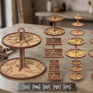 Peut inclure: Une collection de présentoirs à étages en bois découpés au laser, de formes et tailles variées, avec des motifs gravés sur les plateaux. Le texte 6MM 1/4 IN et SVG PNG DXF PDF EPS est visible. Ces supports sont conçus pour être assemblés.