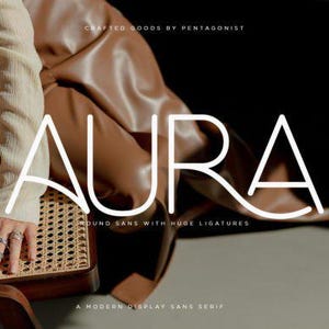 May include: The word "AURA" in white, modern font is displayed over a brown background. The text "CRAFTED GOODS BY PENTAGONIST", "ROUND SANS WITH HUGE LIGATURES", and "A MODERN DISPLAY SANS SERIF" are also visible.