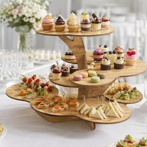 Peut inclure: Un présentoir de service en bois à plusieurs niveaux avec des plateformes courbes organiques contenant un assortiment de cupcakes, macarons, petits desserts et sandwichs. Le côté droit de l'image présente une barre verticale gris foncé avec le texte CDR, PNG, PDF, SVG, DXF, EPS.
