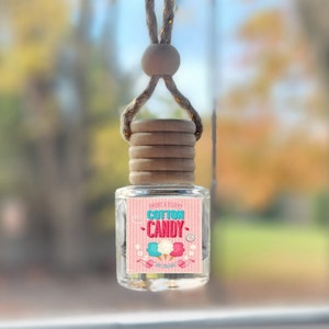 May include: A pink and blue car air freshener with a cotton candy design and the text "Sweet & Fluffy Cotton Candy" and "Car Freshener".