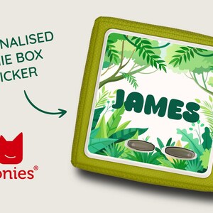 May include: A personalised Tonie Box sticker featuring the name "James" in green, set against a jungle backdrop. The sticker is within a lime green square case with a zip. The Tonies logo is also visible.