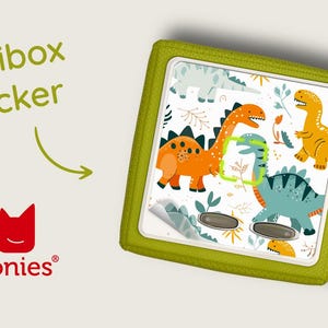 May include: A green Toniebox sticker with a dinosaur pattern. The sticker features a variety of dinosaurs in orange, yellow, and blue colours. The sticker is designed to fit on a Toniebox.