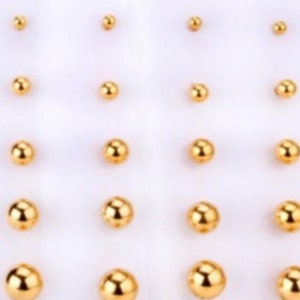 Ball-shaped earrings of different sizes in gold-plated stainless steel of, hypoallergenic.