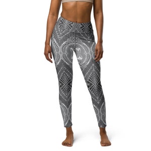 May include: Black leggings with a white geometric pattern. The leggings have a high waist and a tight fit.