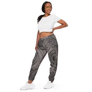 May include: Black and white patterned sweatpants with a relaxed fit. The sweatpants have a drawstring waistband and cuffed ankles.