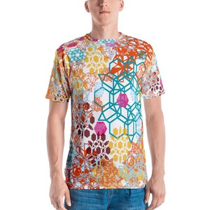 May include: A white t-shirt with a colorful geometric pattern. The pattern features a variety of shapes, including hexagons, squares, and triangles. The colors in the pattern include orange, yellow, blue, green, pink, and brown.