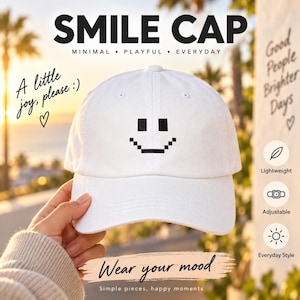 Pode incluir: Um boné de beisebol branco com um gráfico de rosto sorridente pixelizado em preto na frente. O boné inclui o texto SMILE CAP, MINIMAL, PLAYFUL, EVERYDAY, A little joy, please :), Wear your mood, Simple pieces, happy moments e Good People Brighter Days.