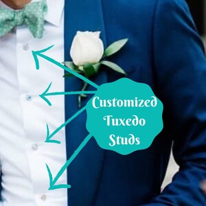 Op de afbeelding: Een donkerblauwe smokingjas met een wit overhemd en een lichtgroene vlinderdas. Een witte rozenknop is op de revers gespeld. De afbeelding bevat de tekst "Customized Tuxedo Studs".