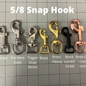 May include: A close-up of 5/8 inch snap hooks in various finishes: nickel, stainless steel, trigger snap nickel, brass heavy, black coated nickel, and rose gold coated nickel.