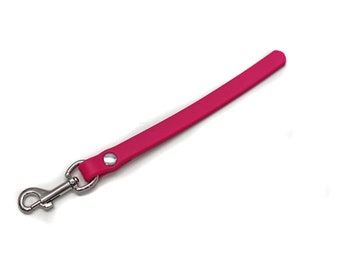 May include: A pink leather leash with a silver metal clip.