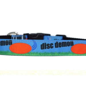 Peut inclure: Un collier de chien bleu avec le texte "disc demon" et un disque rouge.