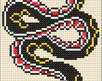 May include: Black and red snake with yellow accents, embroidered on a white background. The snake is coiled in a circular pattern.