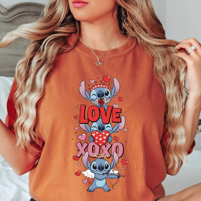 A woman wearing a red t-shirt with a graphic design featuring a cartoon character and the text "LOVE XO XO" surrounded by hearts.