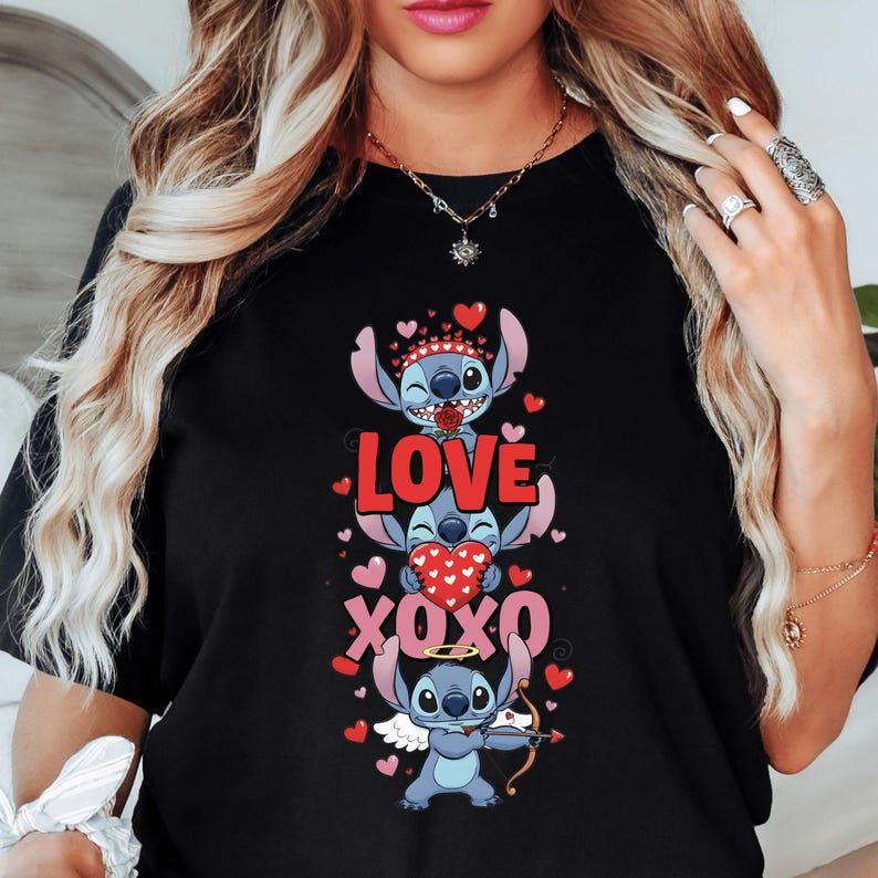 A woman wearing a black t-shirt with a graphic design featuring three cartoon characters and the text "LOVE XO XO" printed on it.