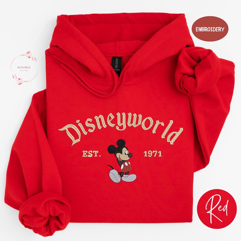 A red hoodie with the text "Disneyworld EST. 1971" and a Mickey Mouse graphic, along with a red embroidered logo and a red circle with the word "Red".
