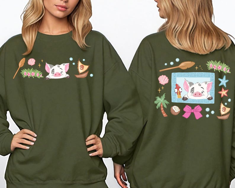 two women wearing green sweatshirts with colorful and whimsical designs, including a pig, flowers, and other decorative elements.